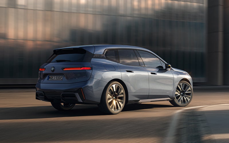 The BMW iX driving with the front wheel turned. | Newbold BMW in O Fallon IL